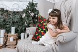 girl in chair with christmas stocking pillow