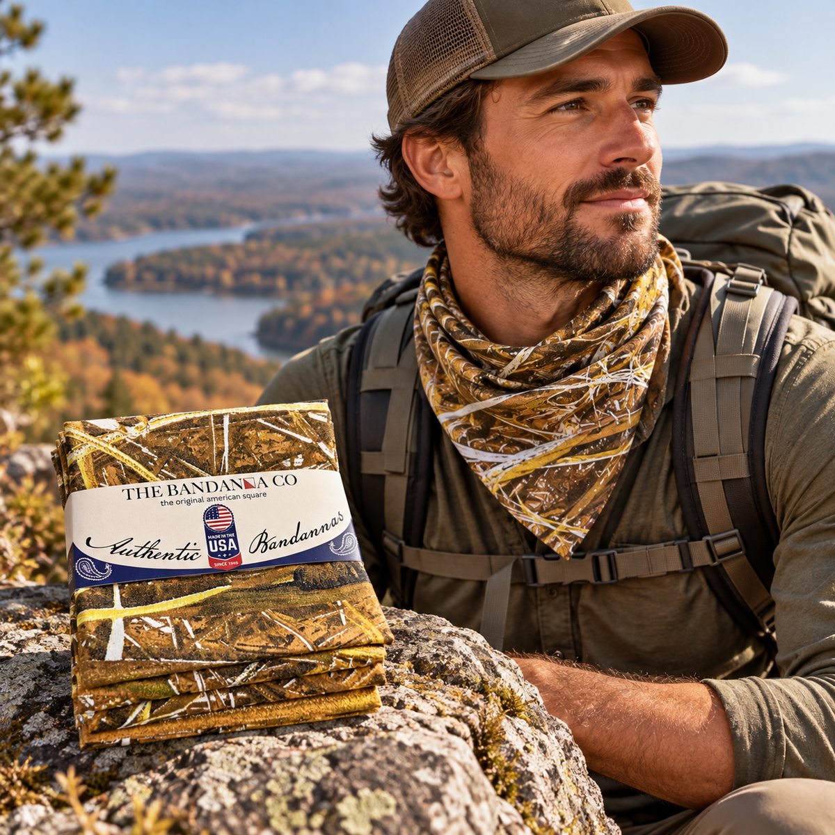 Male hiker on mountain wearing a Blind Site bandana around his neck - 4-pack of bandannas on rock in the foreground with The Bandanna Company logo.