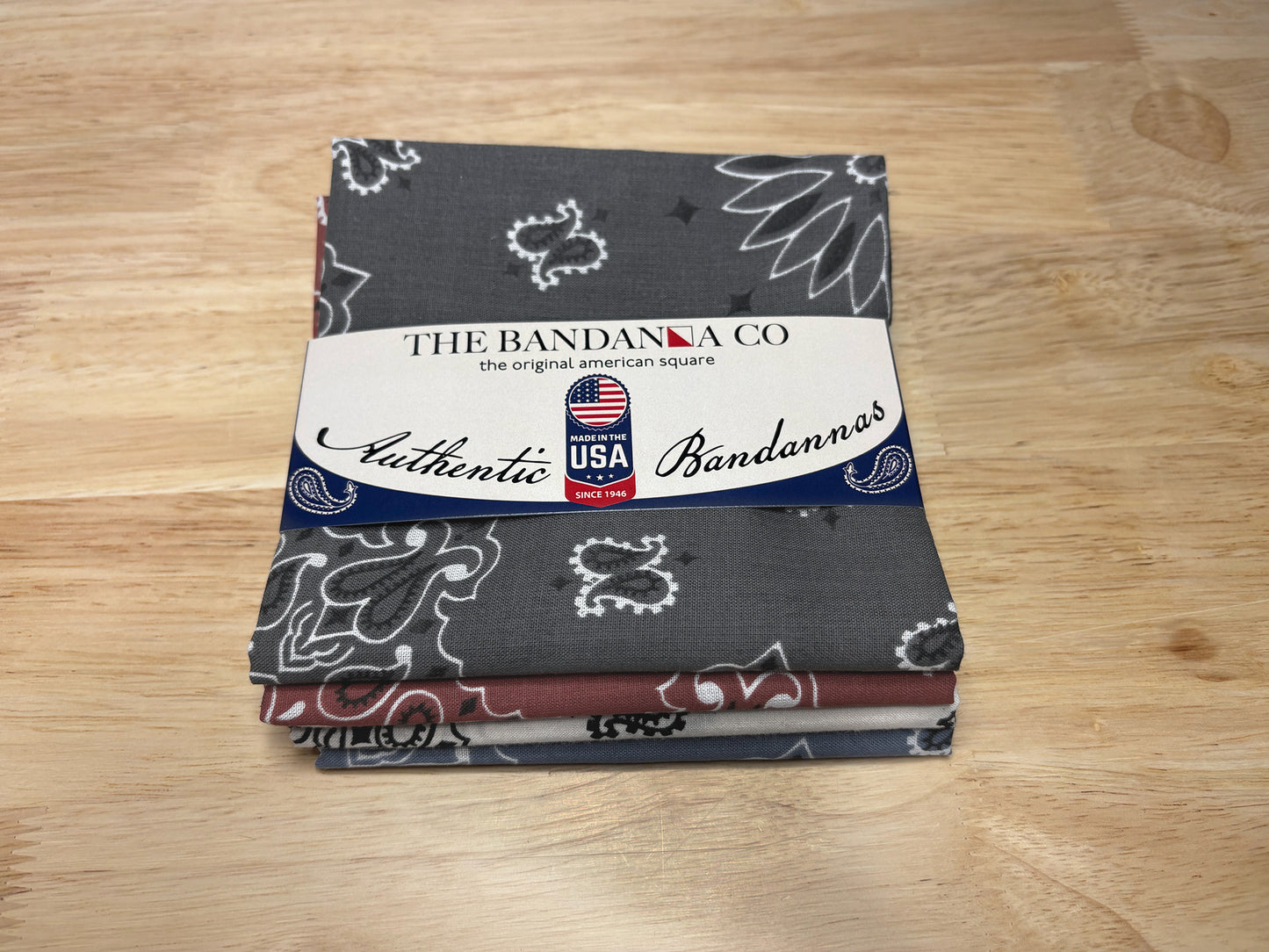 Heritage Bandanna Assortment - 4-Pack - Made In The USA featuring paisley and chambray patterns on a wooden surface.