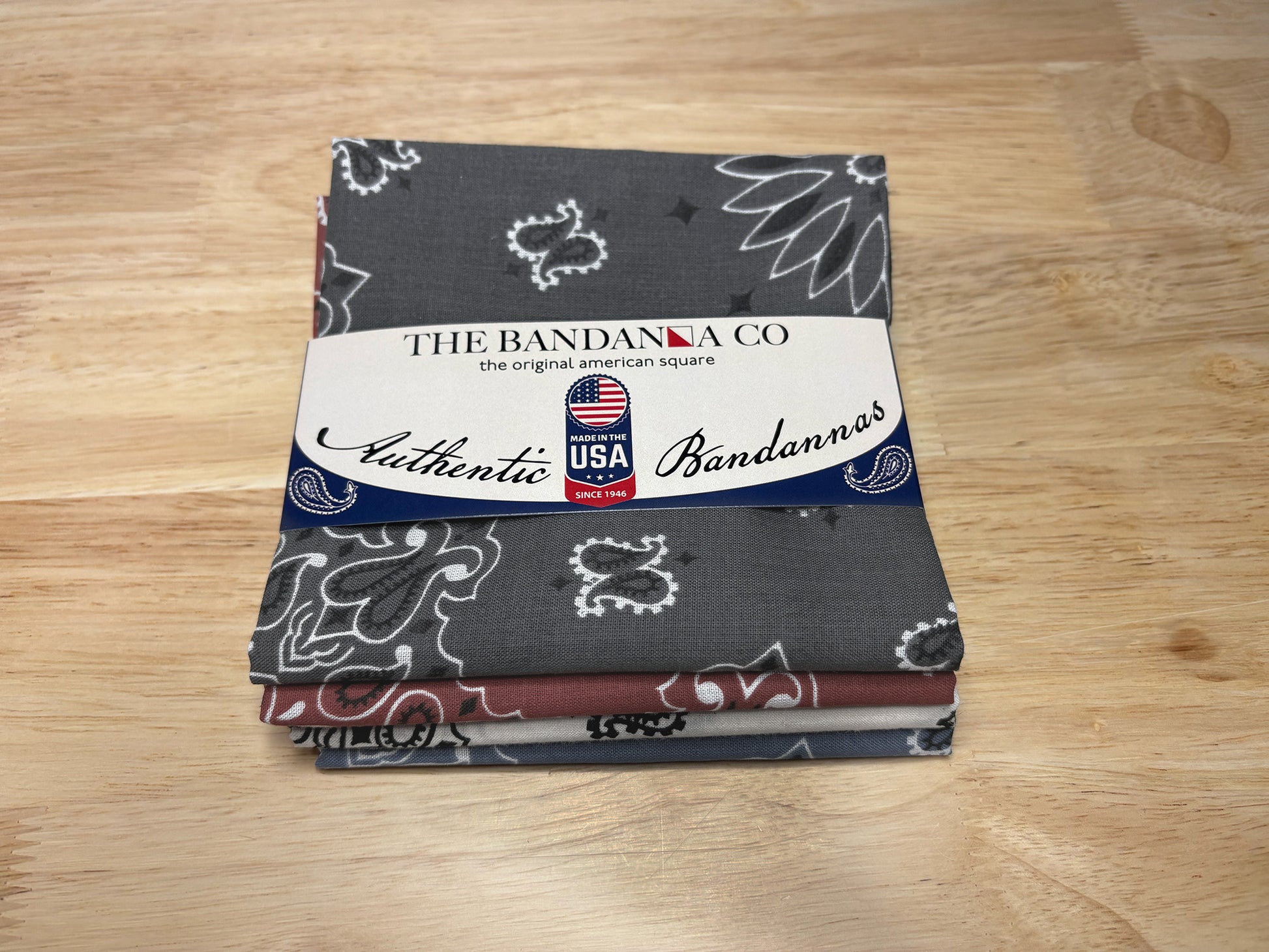 Heritage Bandanna Assortment - 4-Pack - Made In The USA featuring paisley and chambray patterns on a wooden surface.
