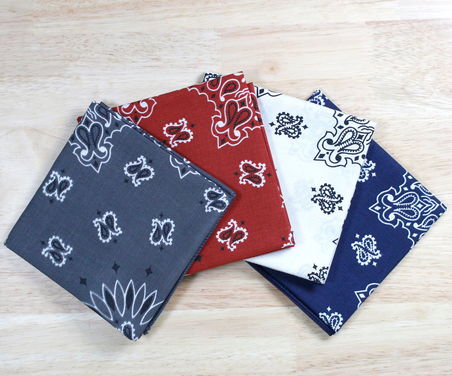 Heartland Bandanna Assortment - Made In The USA featuring four colorful 22" x 22" cotton bandannas on a wooden surface.