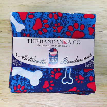 Patriotic Bones Bandanna - 4-Pack - Made In The USA, featuring blue and red pattern with bone designs, 100% cotton, displayed on table.