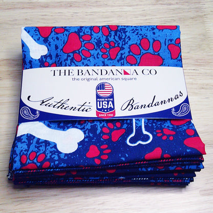 4-pack of Patriotic Bones Bandanna, 100% cotton, made in the USA with bone and paw print design, folded with label showing authenticity.