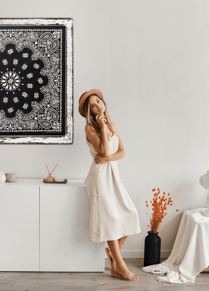 girl standing next tr 35" framed black bandanna on wall